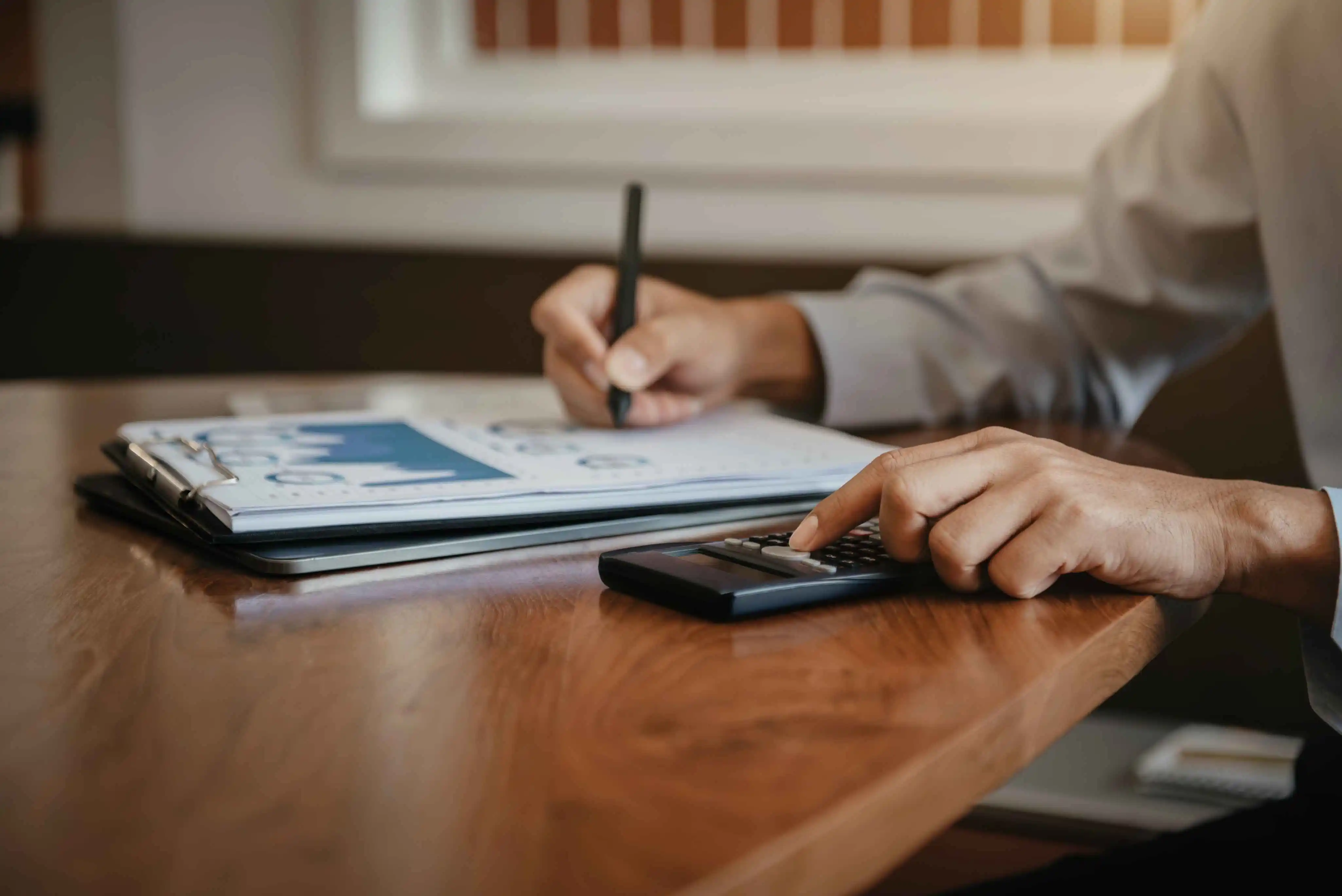 Calculator and documents for rental income calculations on a table.