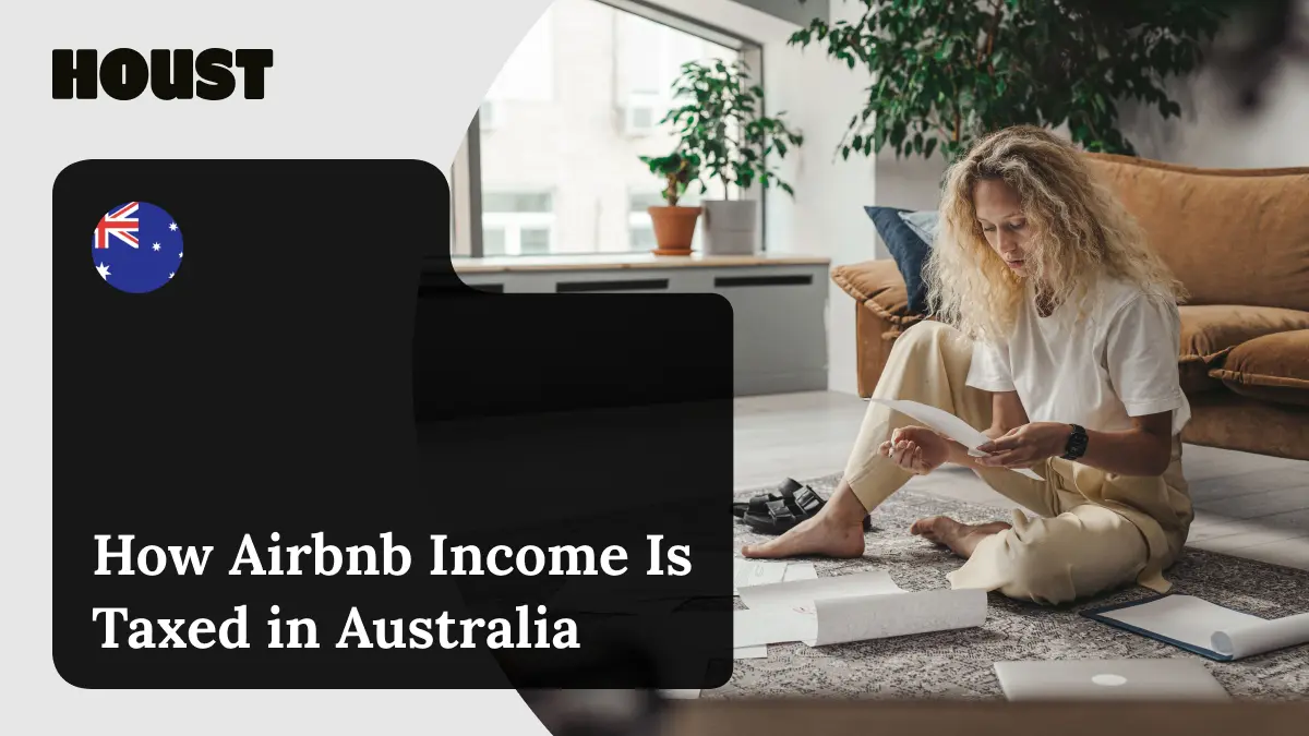 Woman sitting on a living room floor reading receipts and paperwork, featured image for Houst's guide to how Airbnb income is taxed in Australia