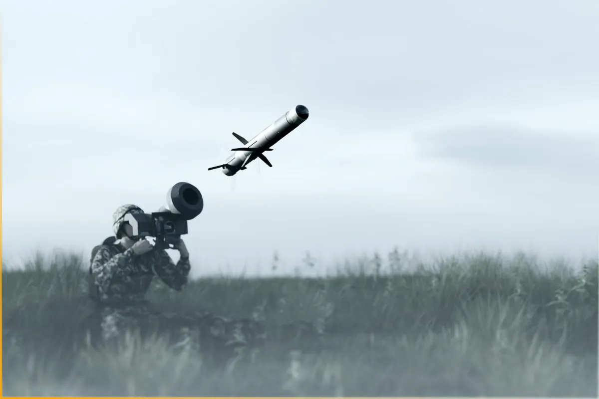 Soldier in camouflage firing an anti-tank missile from a launcher in a grassy field.