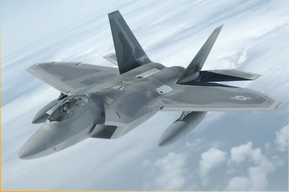 Gray military fighter jet flying above clouds with pilot visible in cockpit.