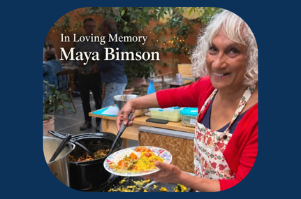 A photo of Maya smiling at the camera, while filling a bowl with food.
