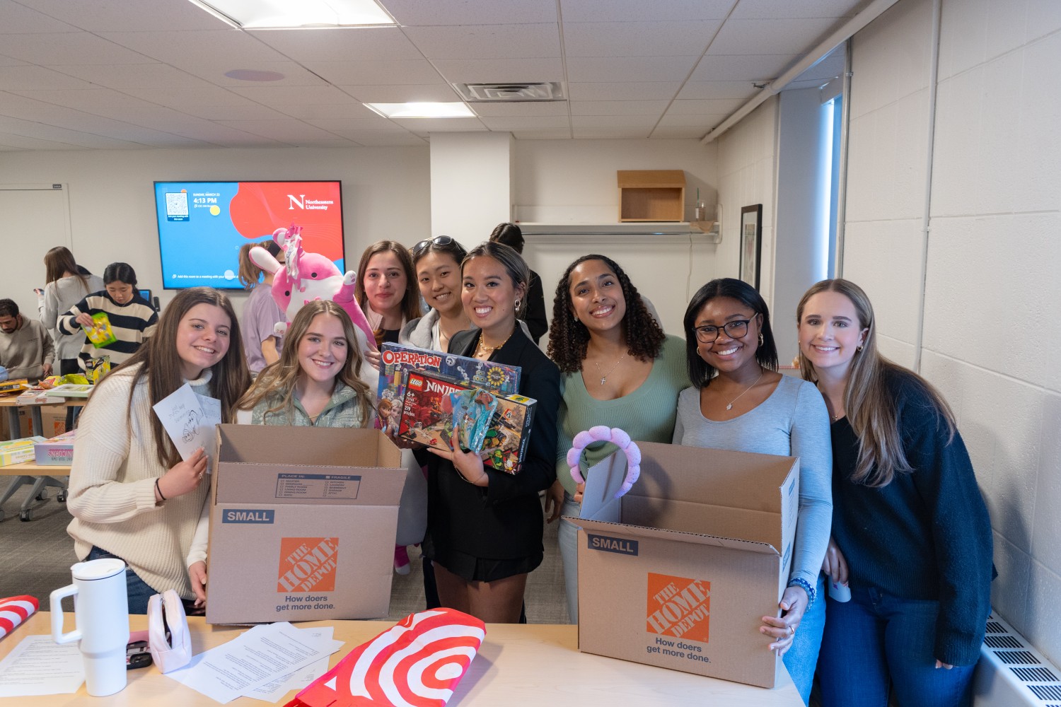 Olivia packing toys for Cancer Kids First with members of the organisation
