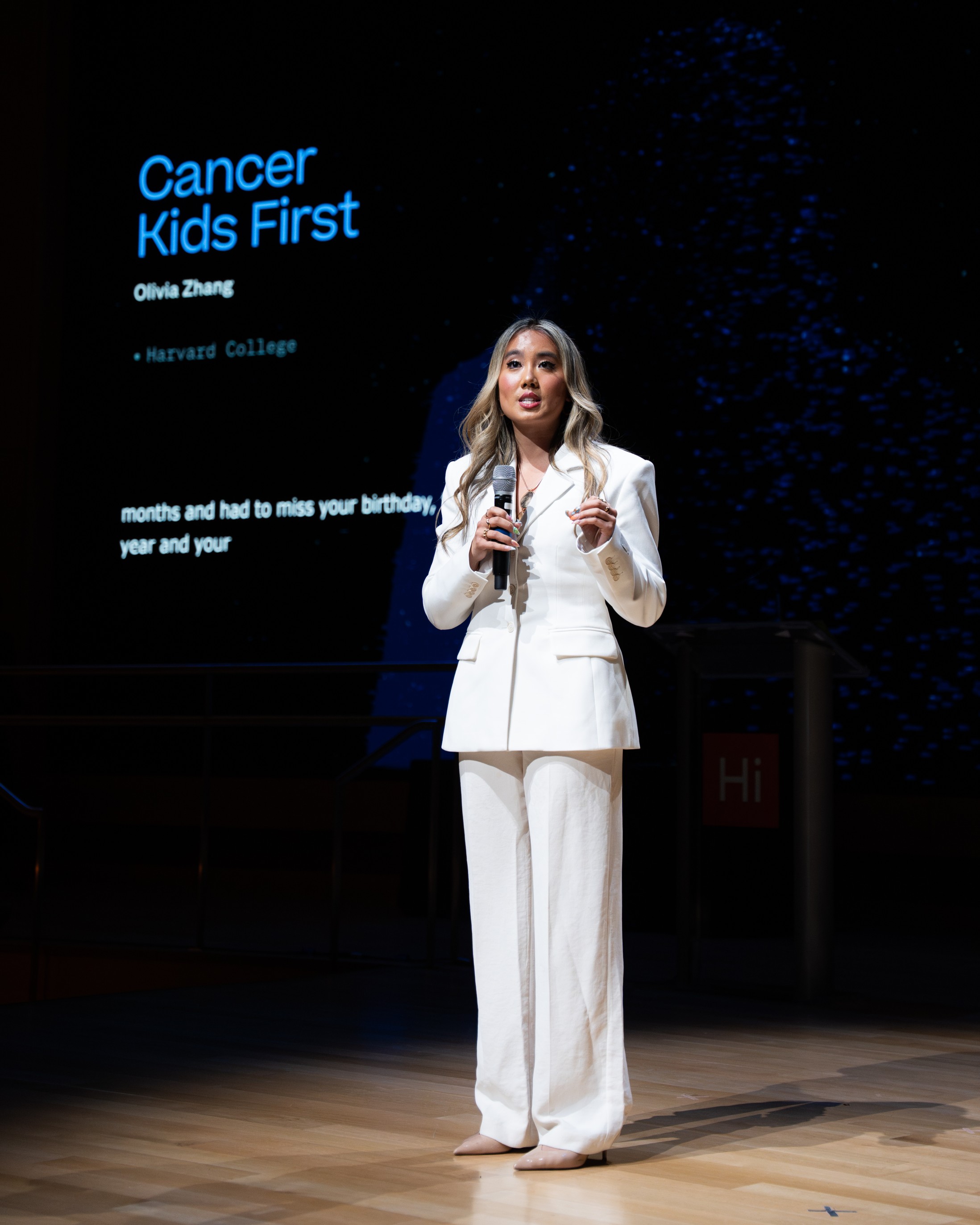 Olivia standing on stage as the youngest founder finalist in the Harvard Innovation Labs' President's Innovation Challenge Social Impact Track