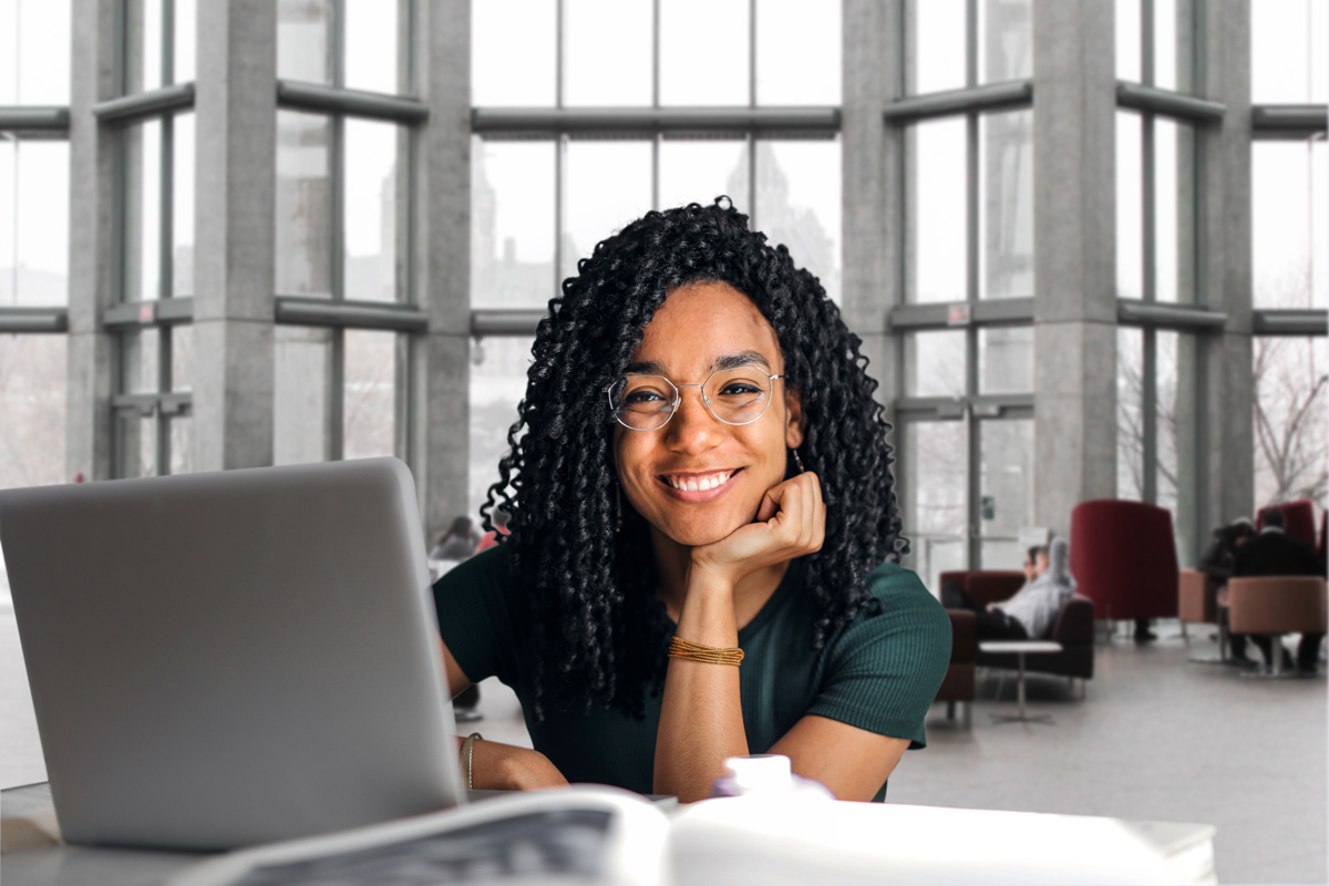 Girl sitting on her laptop and smiling for the camera