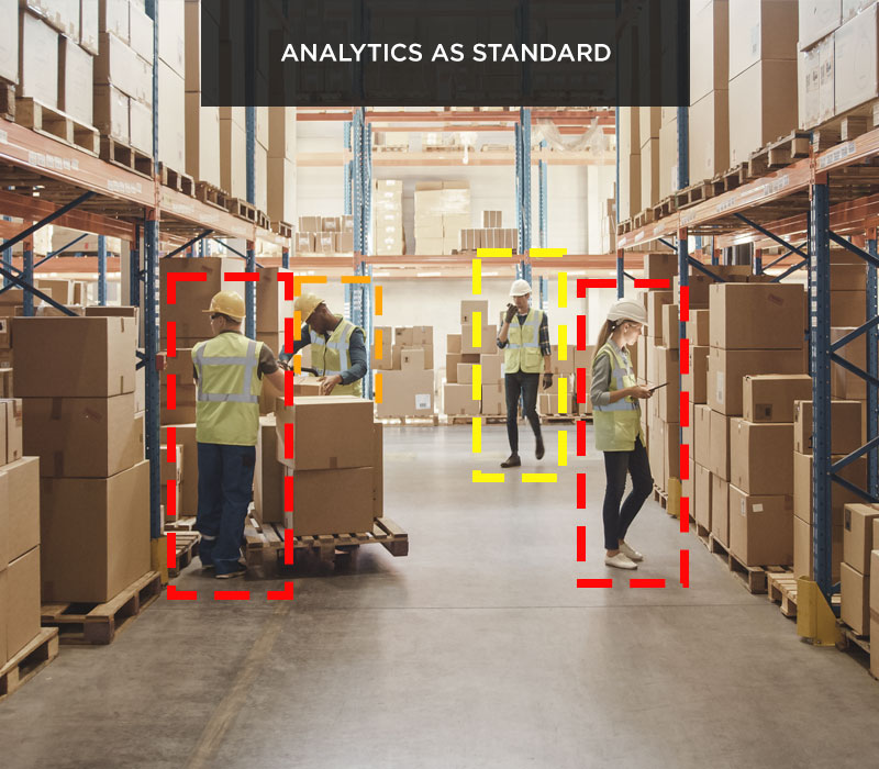 Four workers down a warehouse aisle, all working and surrounded by SensorZone detection boxes.