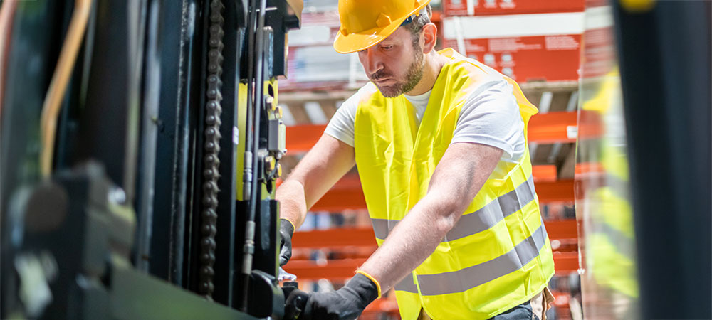 A mechanic in a warehouse installing SensorZone onto a forklift