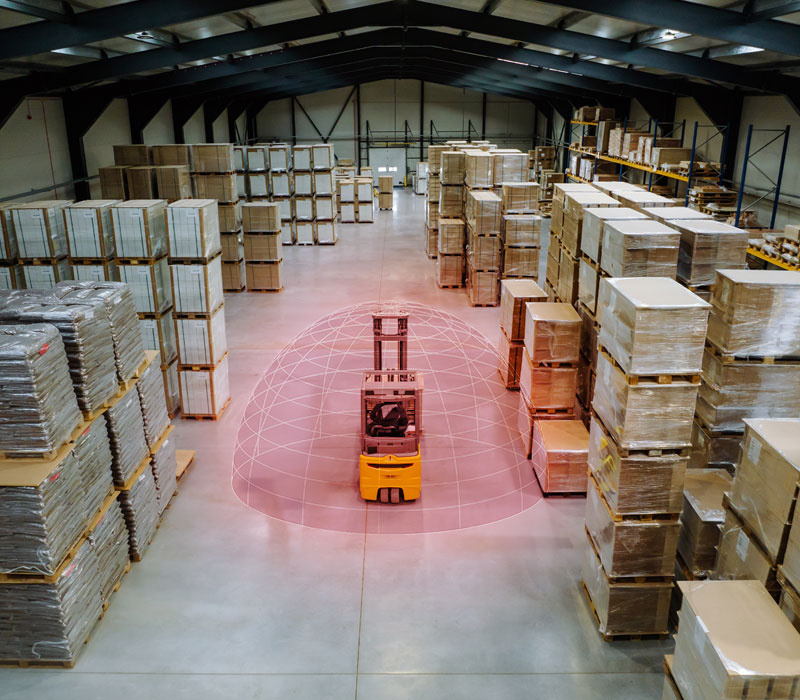 A forklift moving through a warehouse with a SensorZone detection bubble superimposed around it.