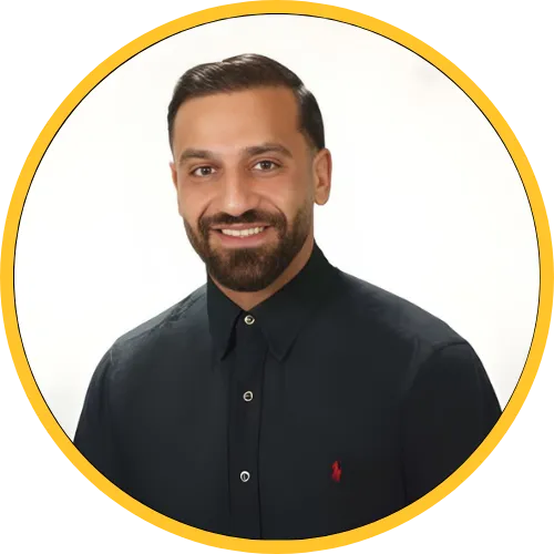 Smiling man with dark hair and beard wearing a black button-up shirt against a white background.