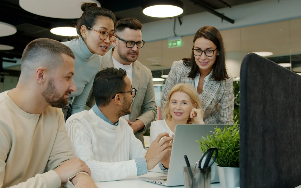 Team bespreekt samen de resultaten op een laptop op kantoor