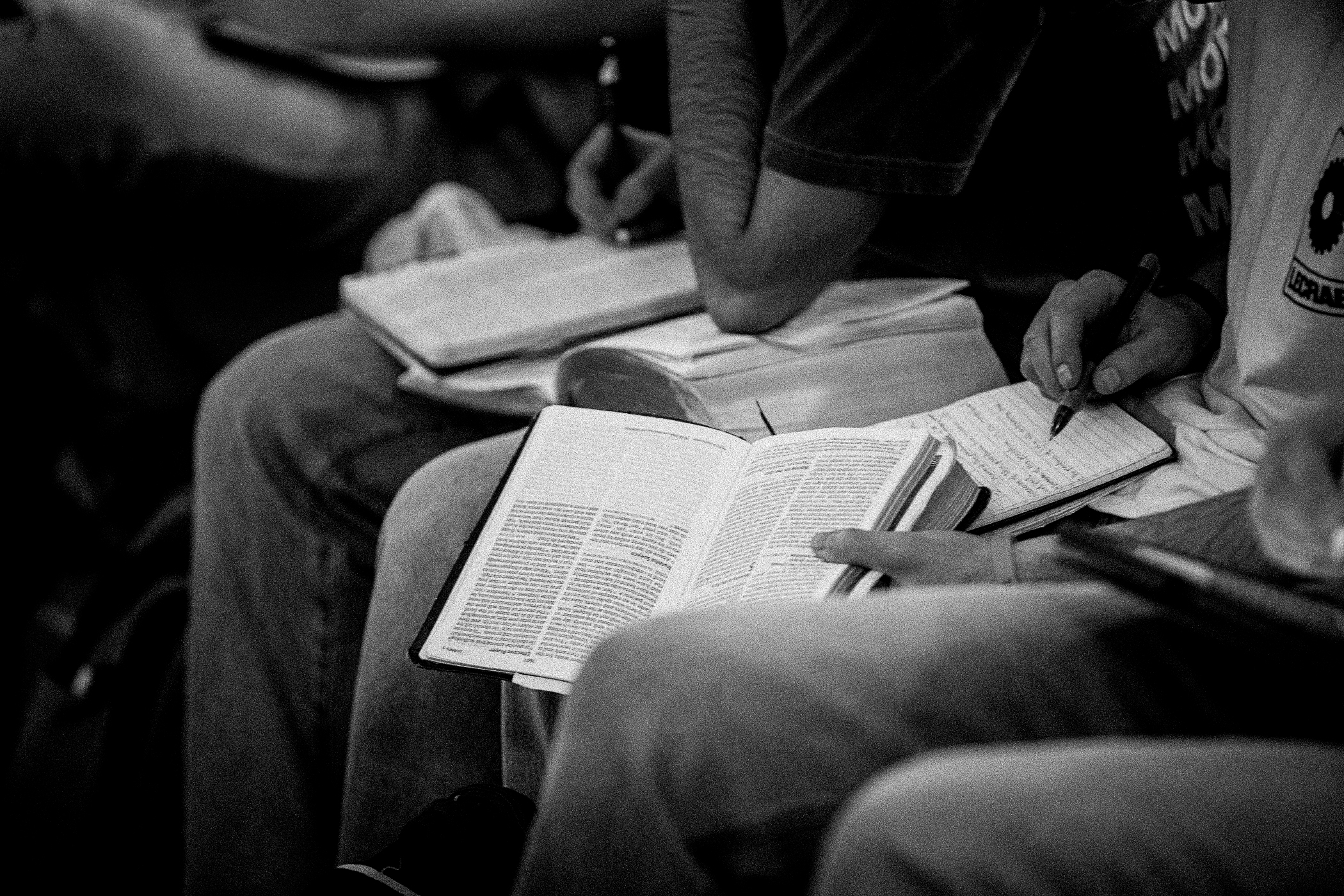 Attendees reading Scripture and taking notes during a CROSS session