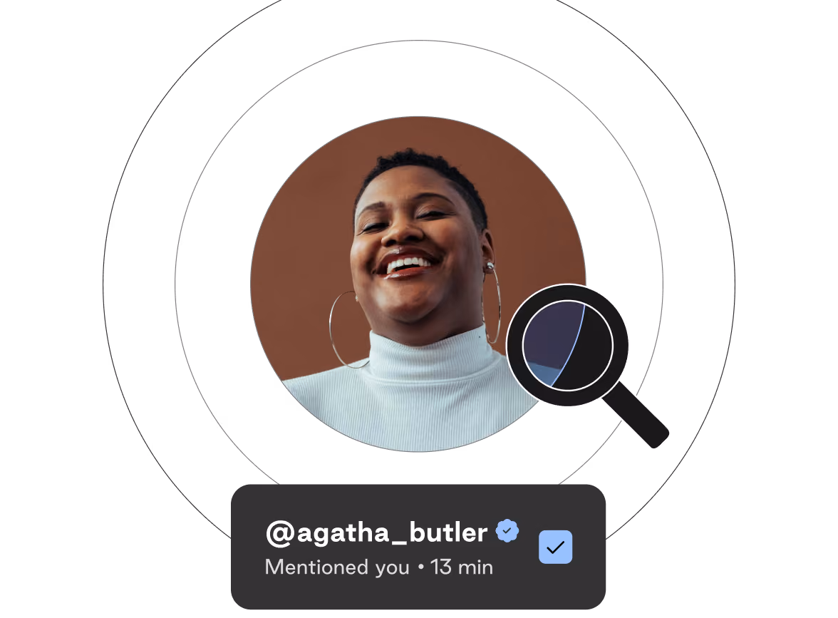 Smiling person with short hair wearing a white turtleneck and large hoop earrings in a circular frame, with a black magnifying glass icon over the right side and a notification box below showing a verified username '@agatha_butler' and text 'Mentioned you • 13 min'.