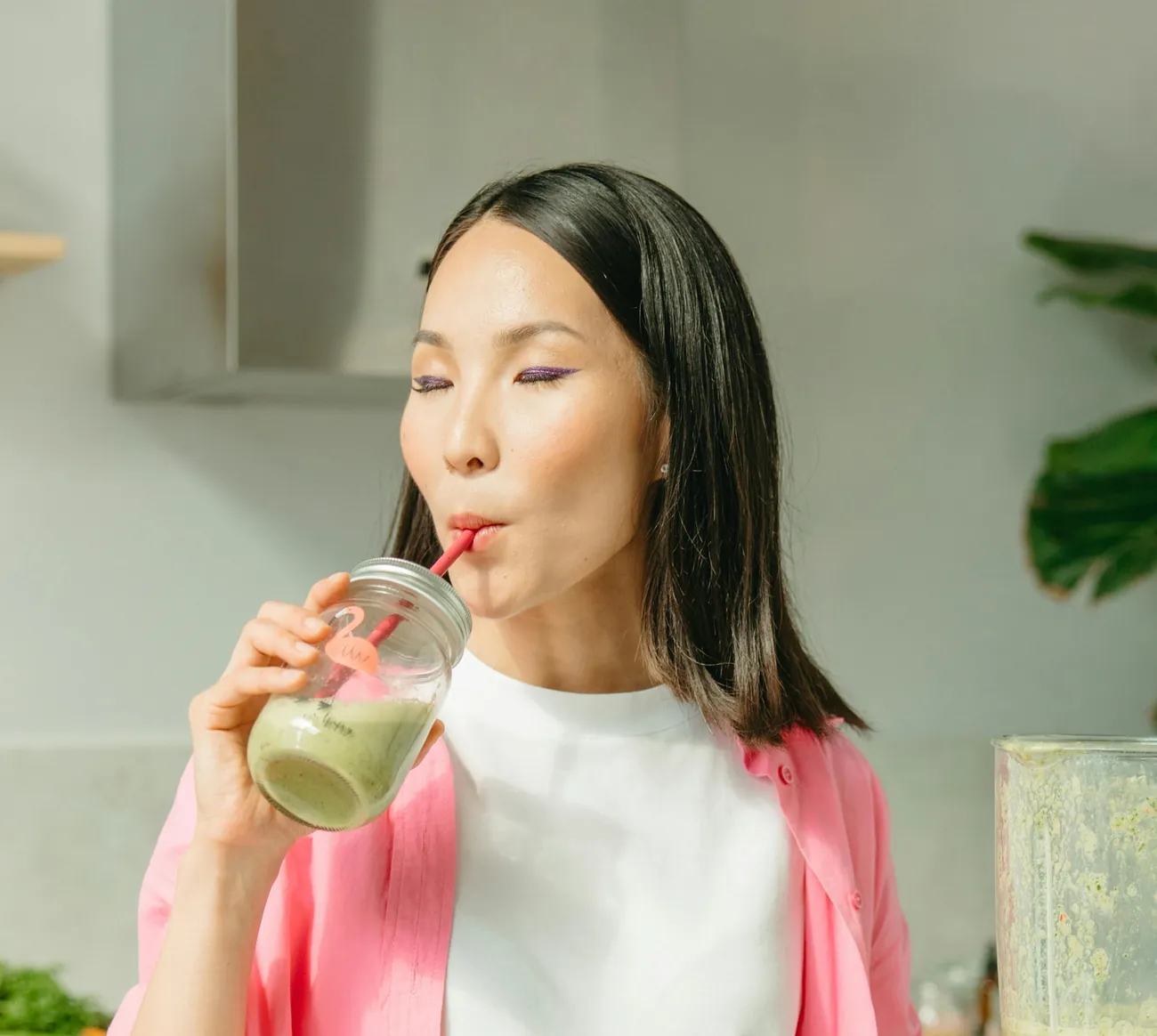 Joanne Kim, a SuperCollabs creator, sipping a green smoothie in her kitchen