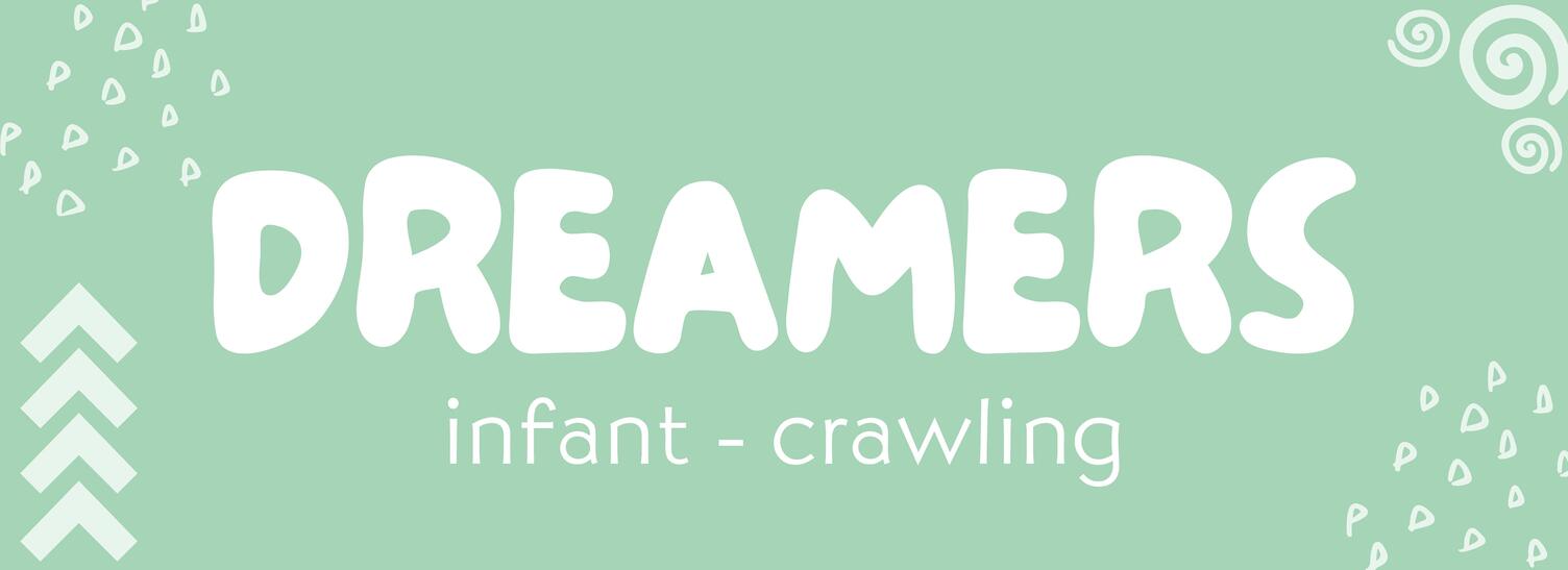 A woman smiling as another woman hands over her child to her.