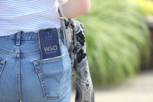 A person with their phone in their back pocket showing the WSA logo