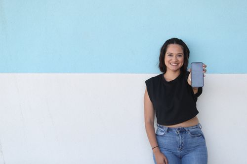 A young woman holding up a freshly fixed phone from WSA