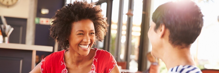 Two women smiling and talking.