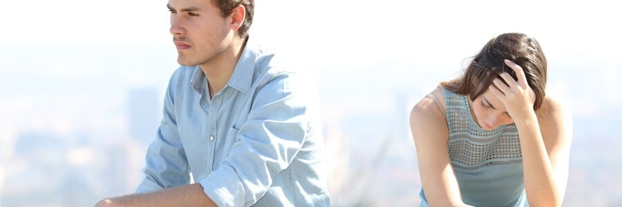 A couple looking upset outdoors.