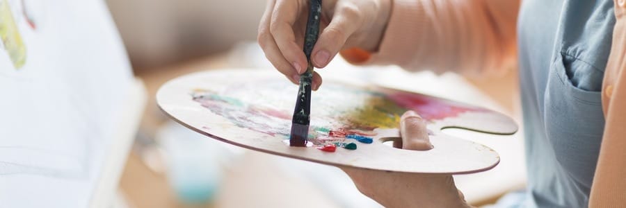 Person painting with a palette.