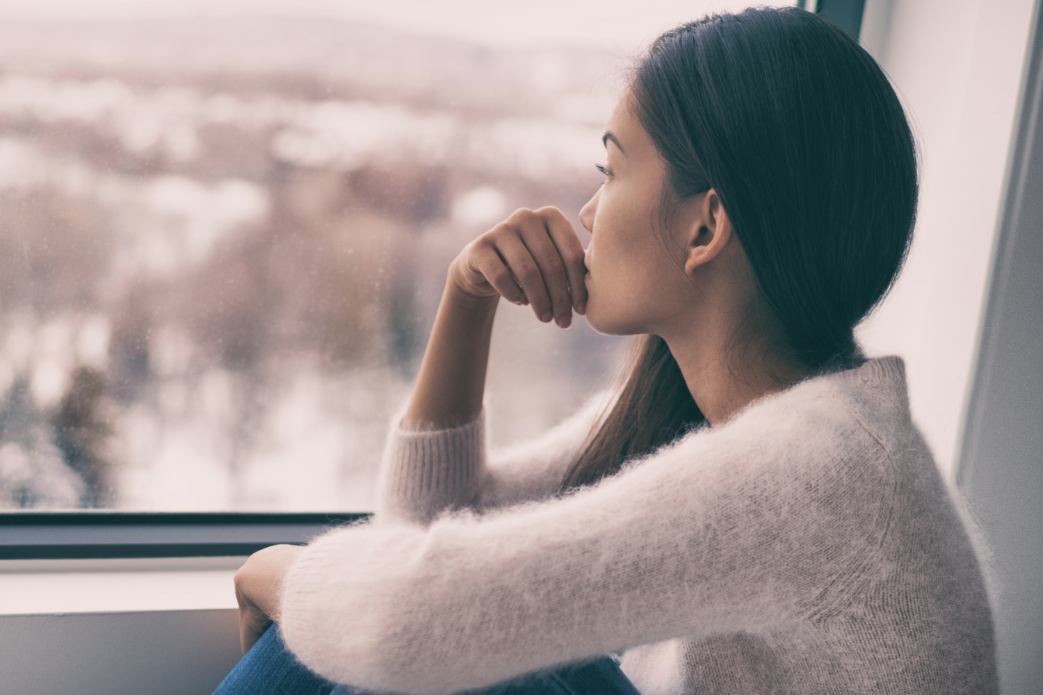 Woman gazing thoughtfully out window