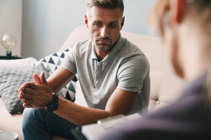 Man in therapy session looking pensive.