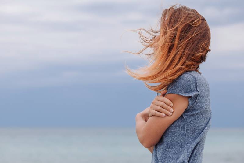 Woman by sea, wind in hair