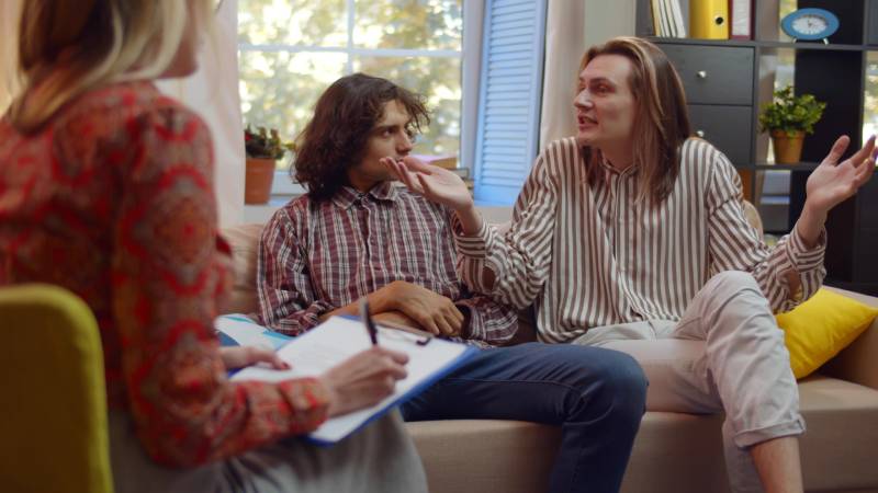 Therapist in session with two LGBTQIA+ individuals.