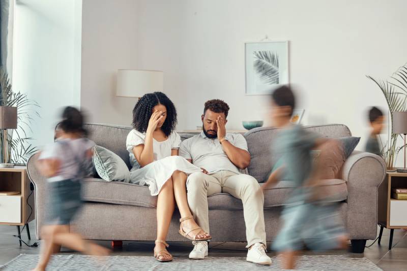 Parents look stressed as kids run around.