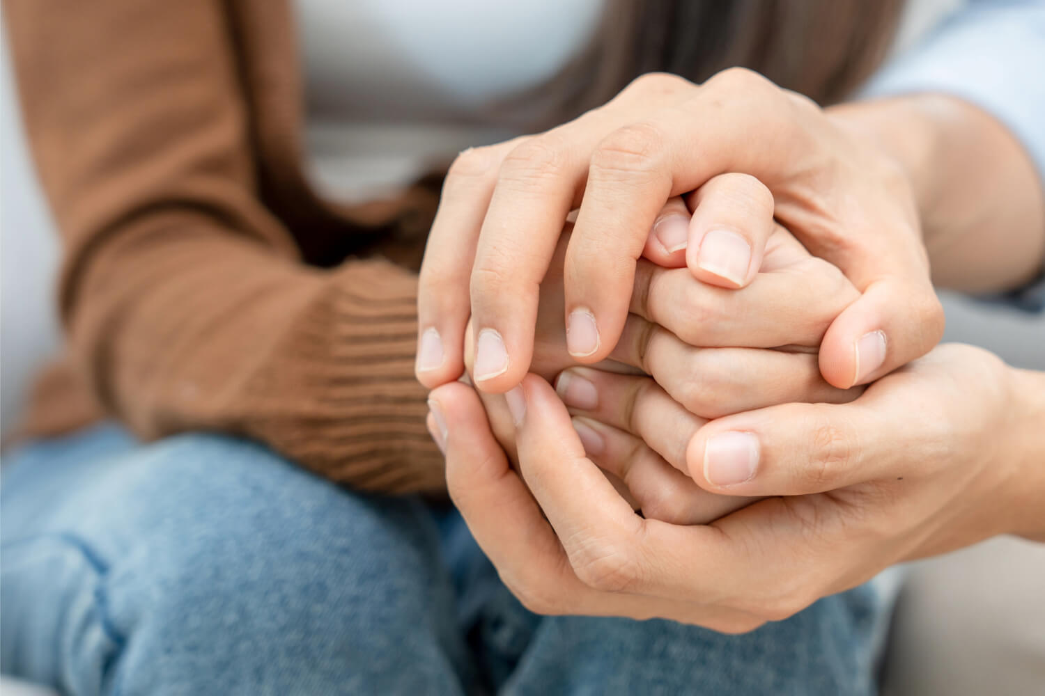 Hands clasped in supportive gesture