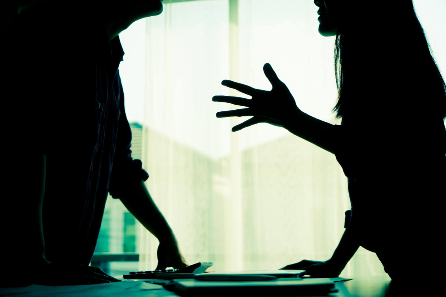 Silhouetted couple arguing.