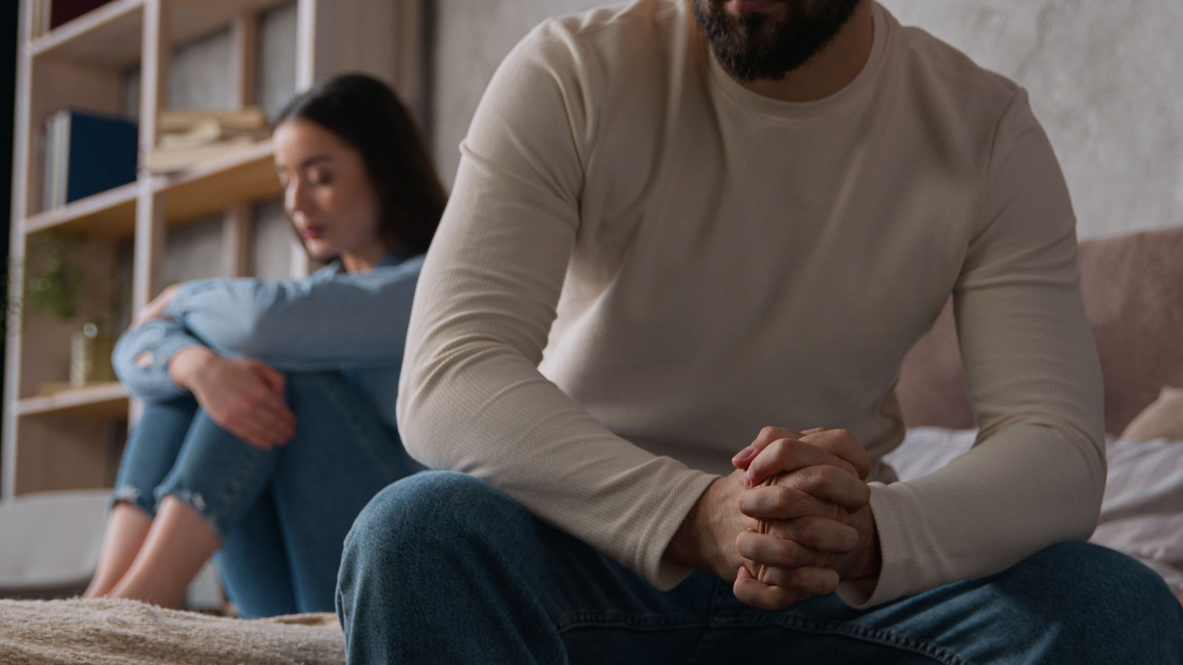 A couple sitting apart, looking contemplative.