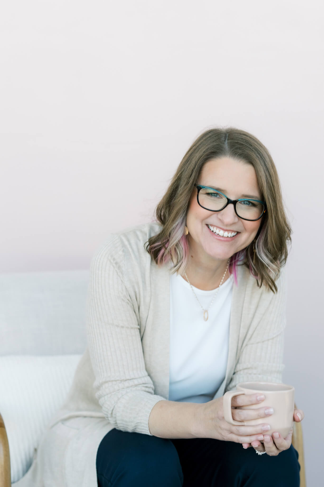 Emily Harrington-Cheney smiling, seated, holding a mug.