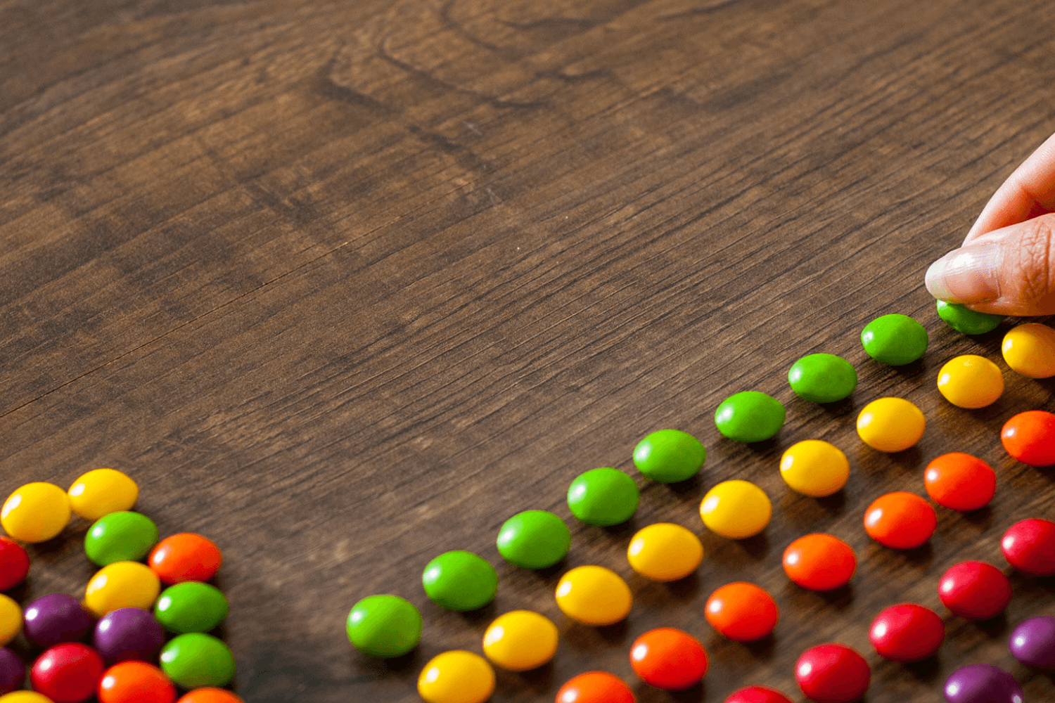 Colorful candies aligned in rows on a table.