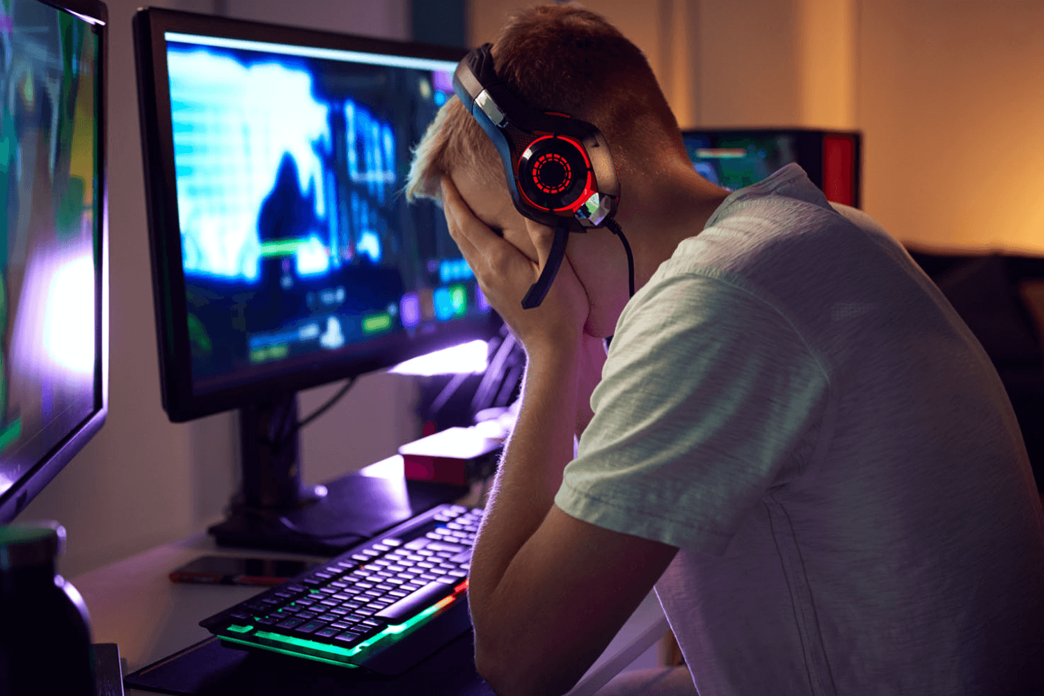 Gamer in distress with head in hands.
