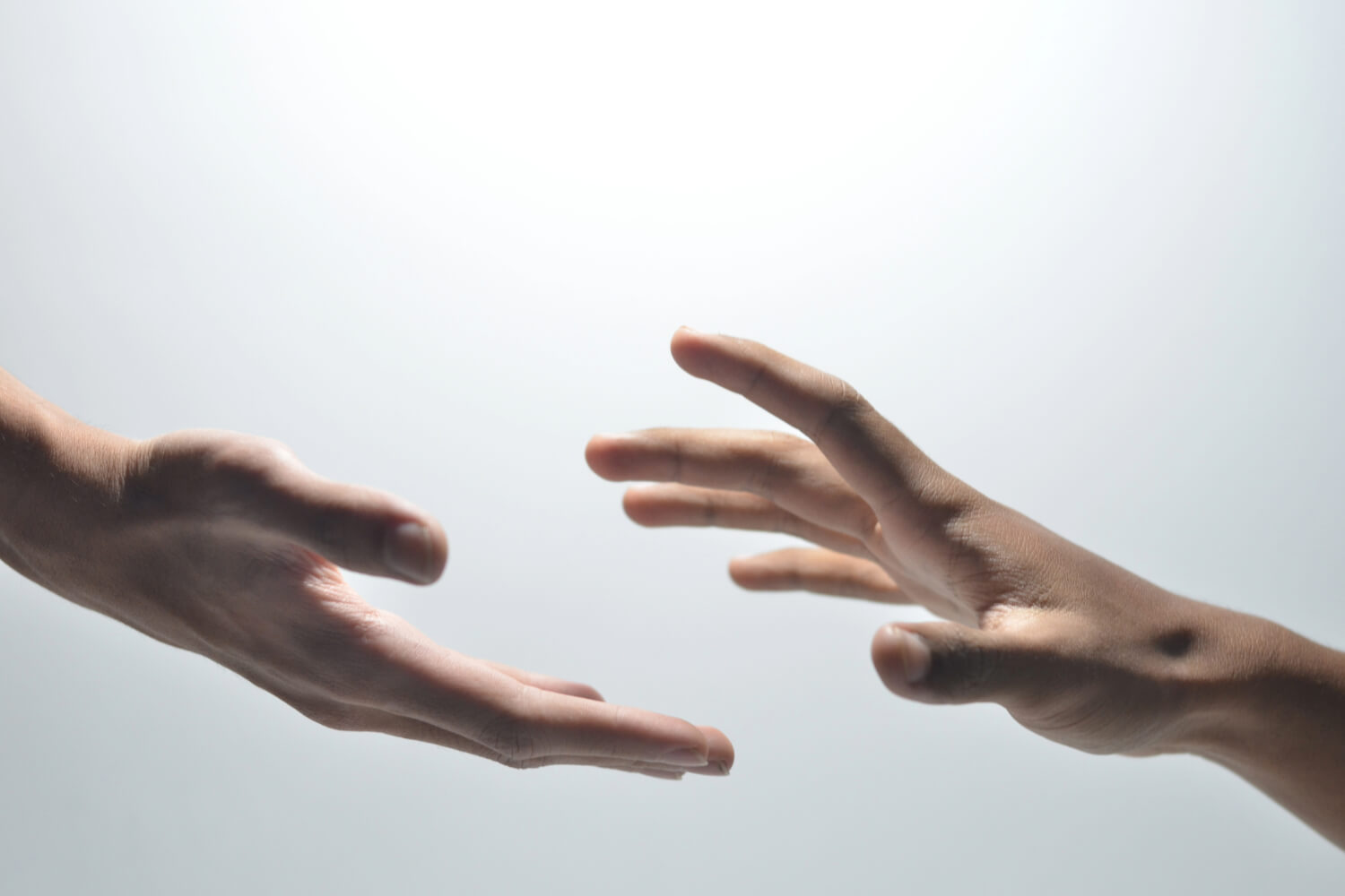 Two hands reaching towards each other.