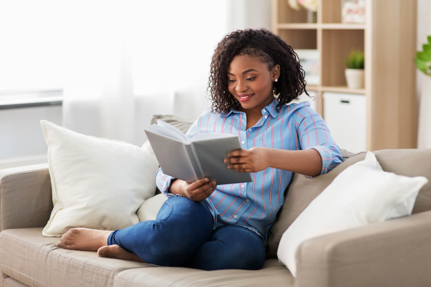 Woman reading book on couch