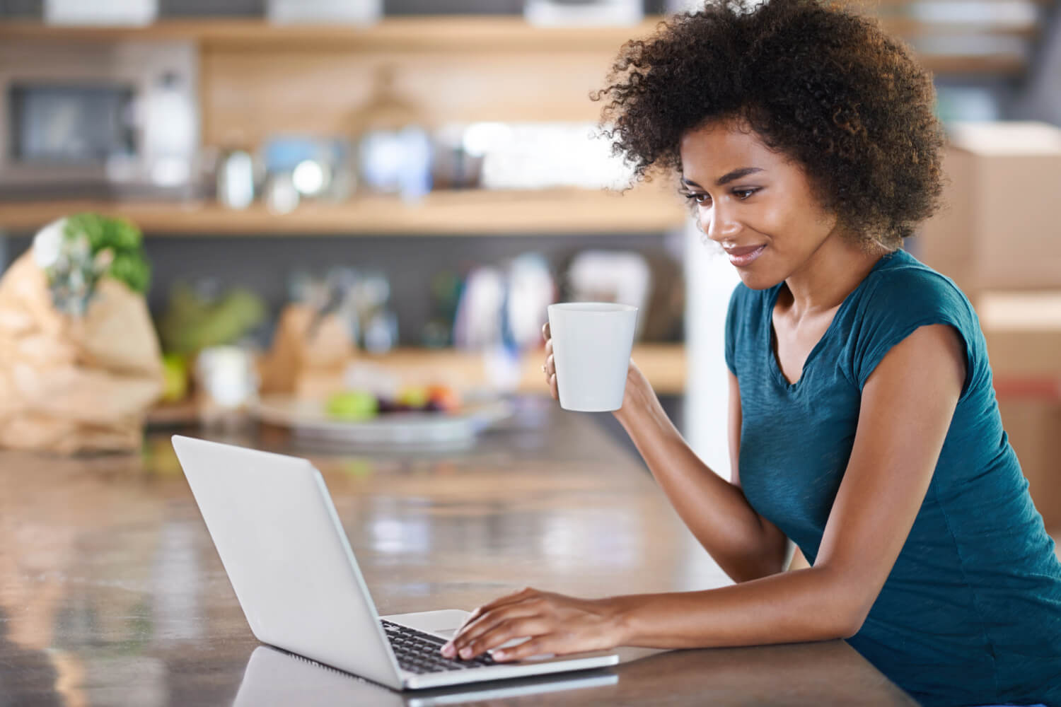 Woman on laptop with mug