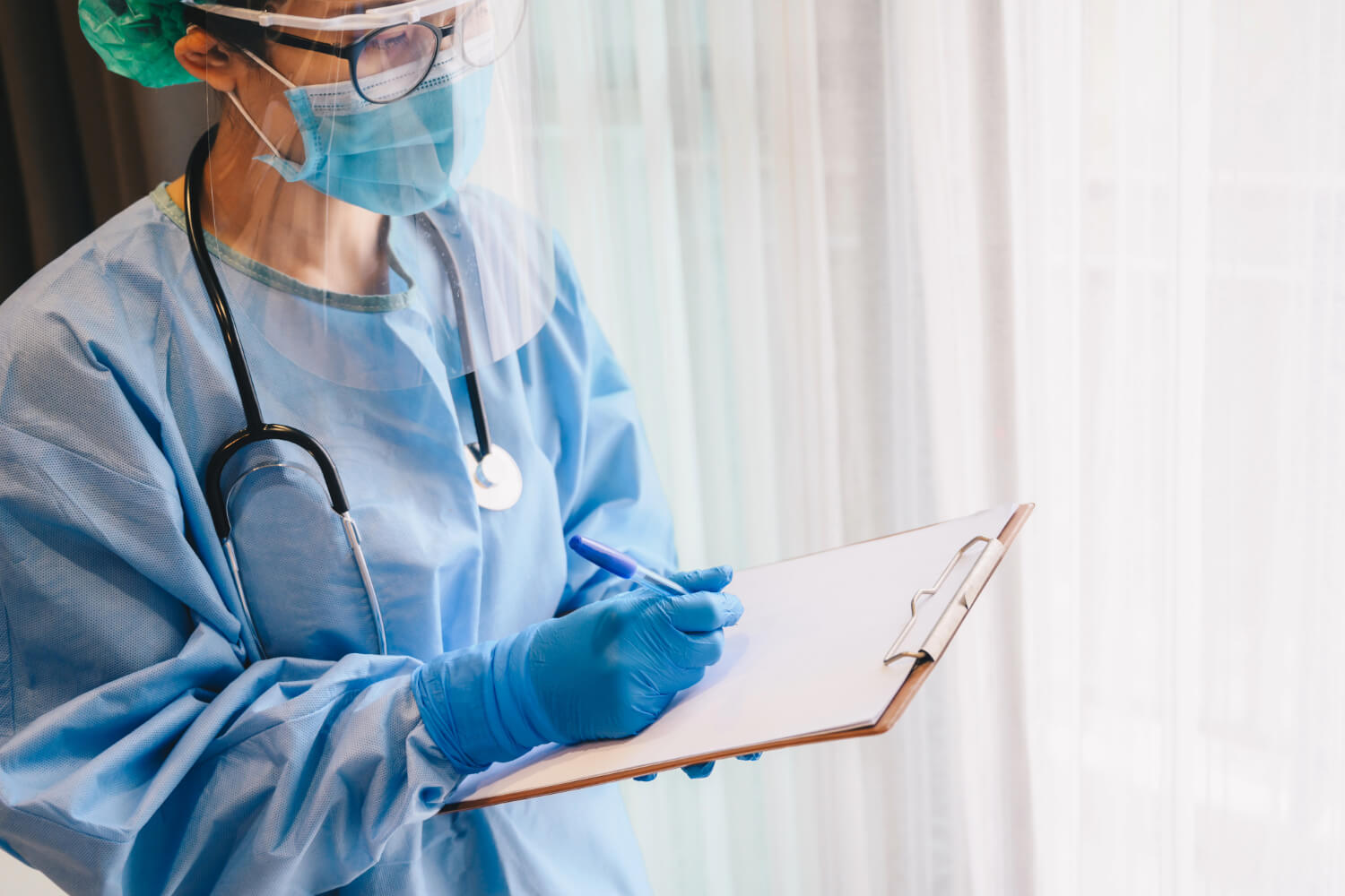 Healthcare worker in PPE with clipboard
