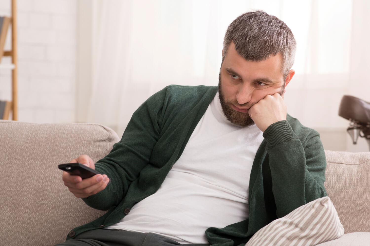 Man bored with remote on couch