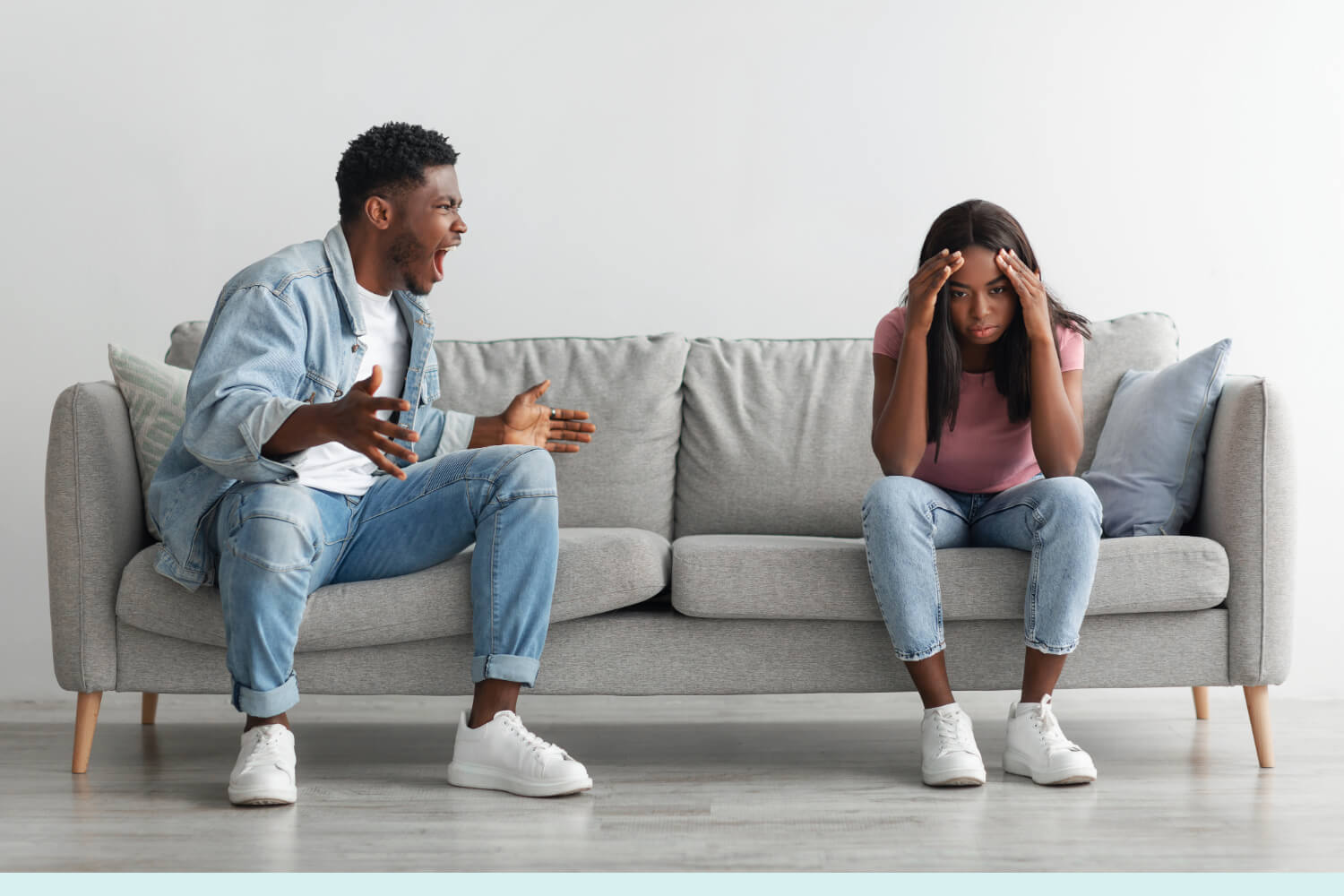 Man angrily yelling; woman upset on sofa.