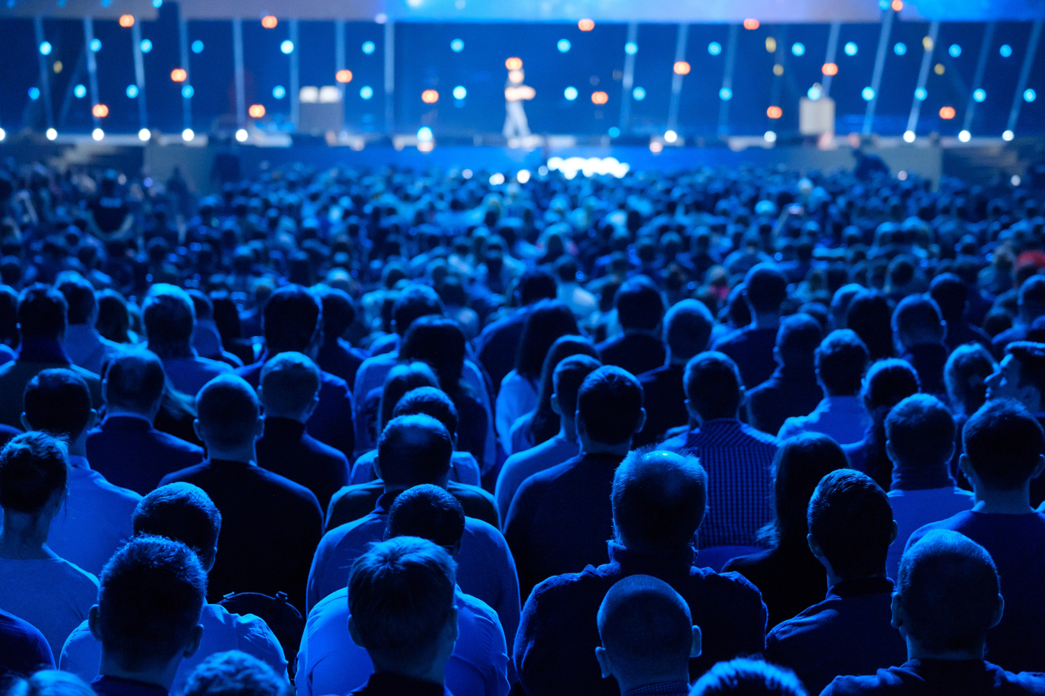 Large audience watching a speaker on stage.