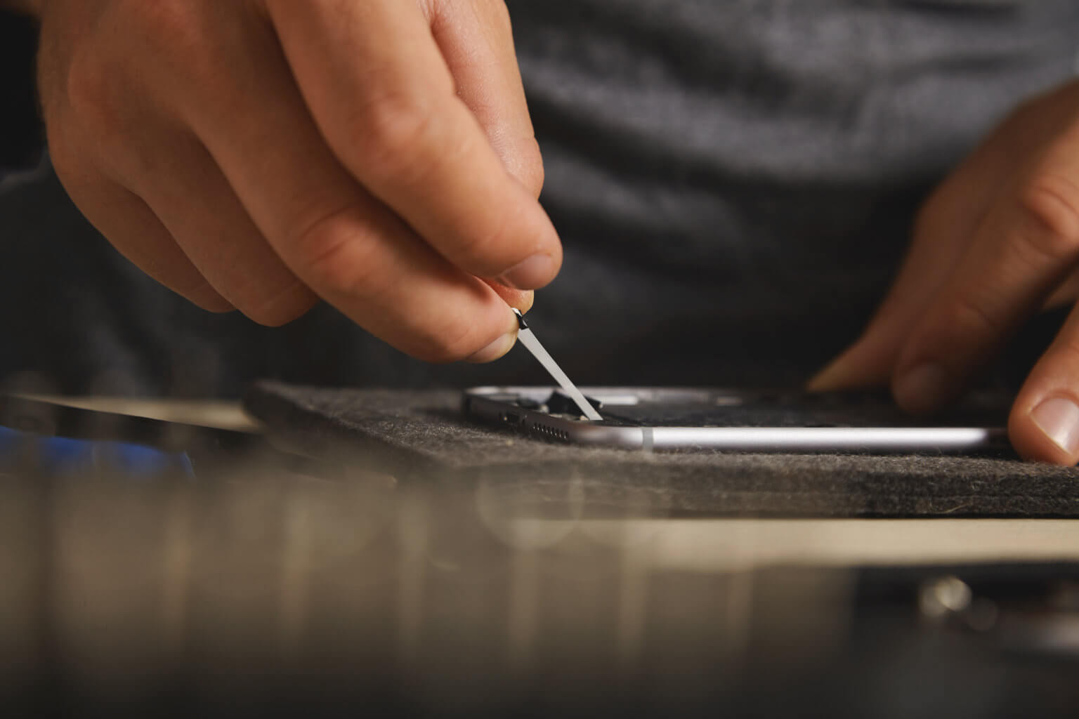 Technician using a small tool to repair a phone