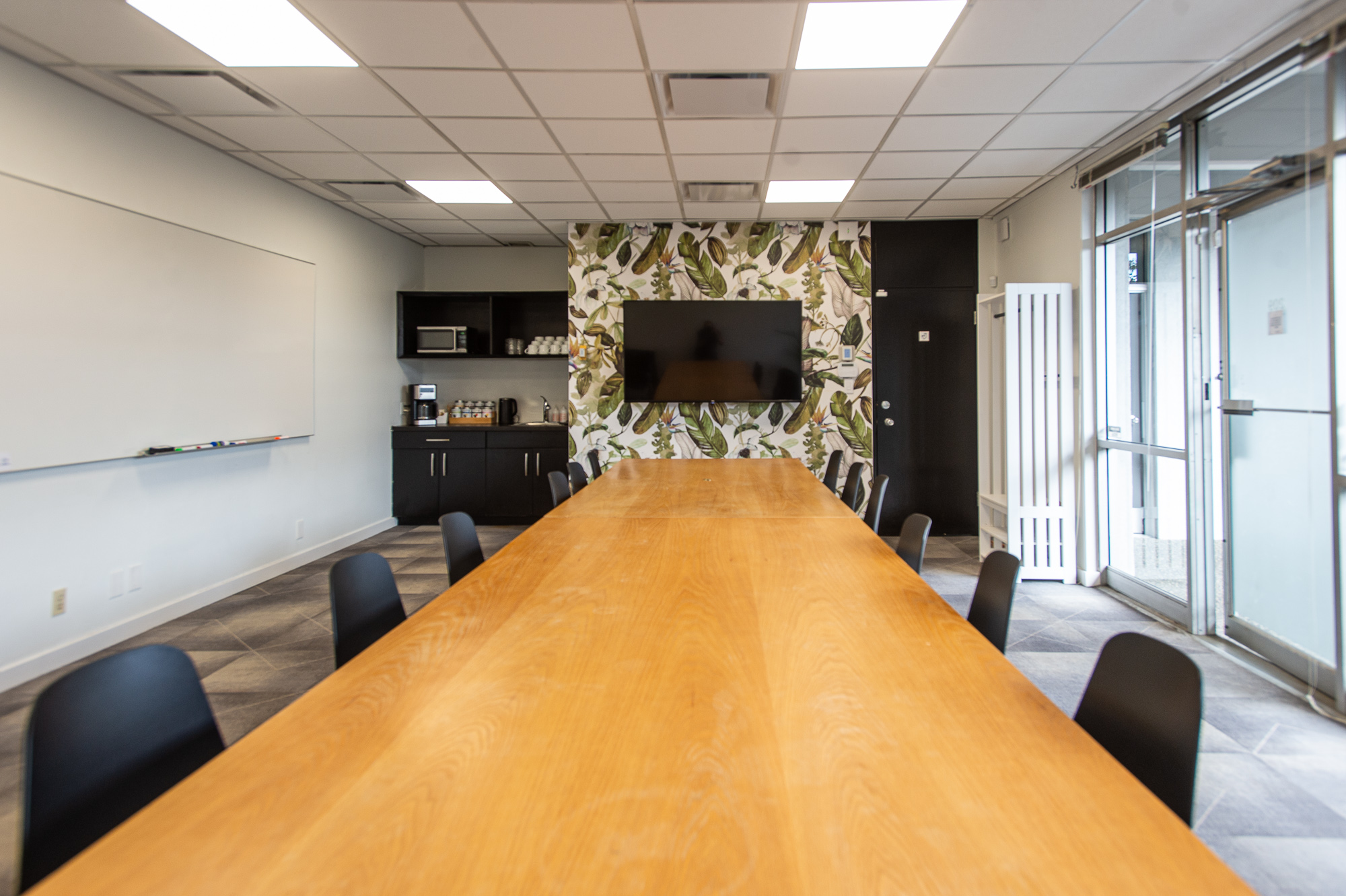 View down the boardroom table to the kitchenette and feature wallpaper