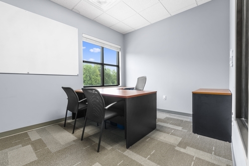 Two men holding camera equipment, talking.