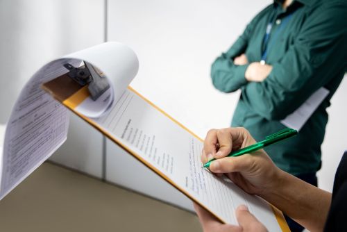 an auditor certifying a company. She is using a clipboard