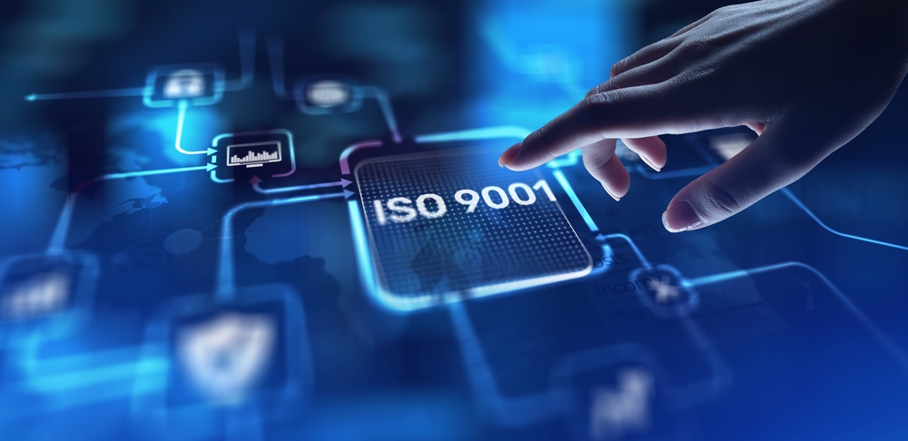 a finger touching a blue screen with ISO 9001 written on it