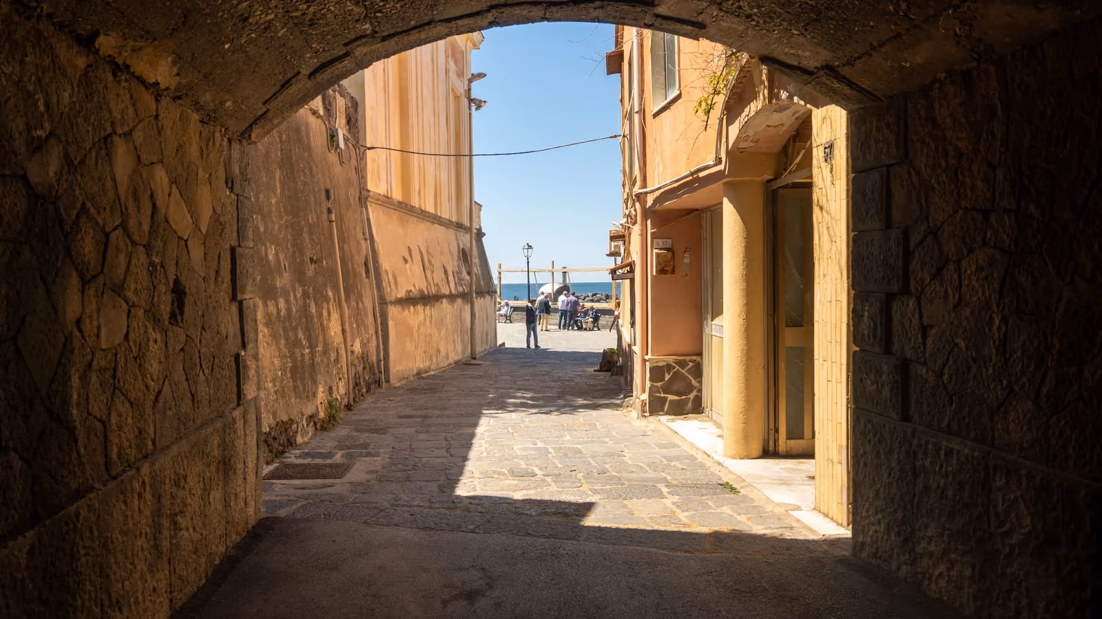 Un pittoresco vicolo che conduce a una vista panoramica sul mare in un'incantevole cittadina italiana. — Ciro Palomba – Pexels