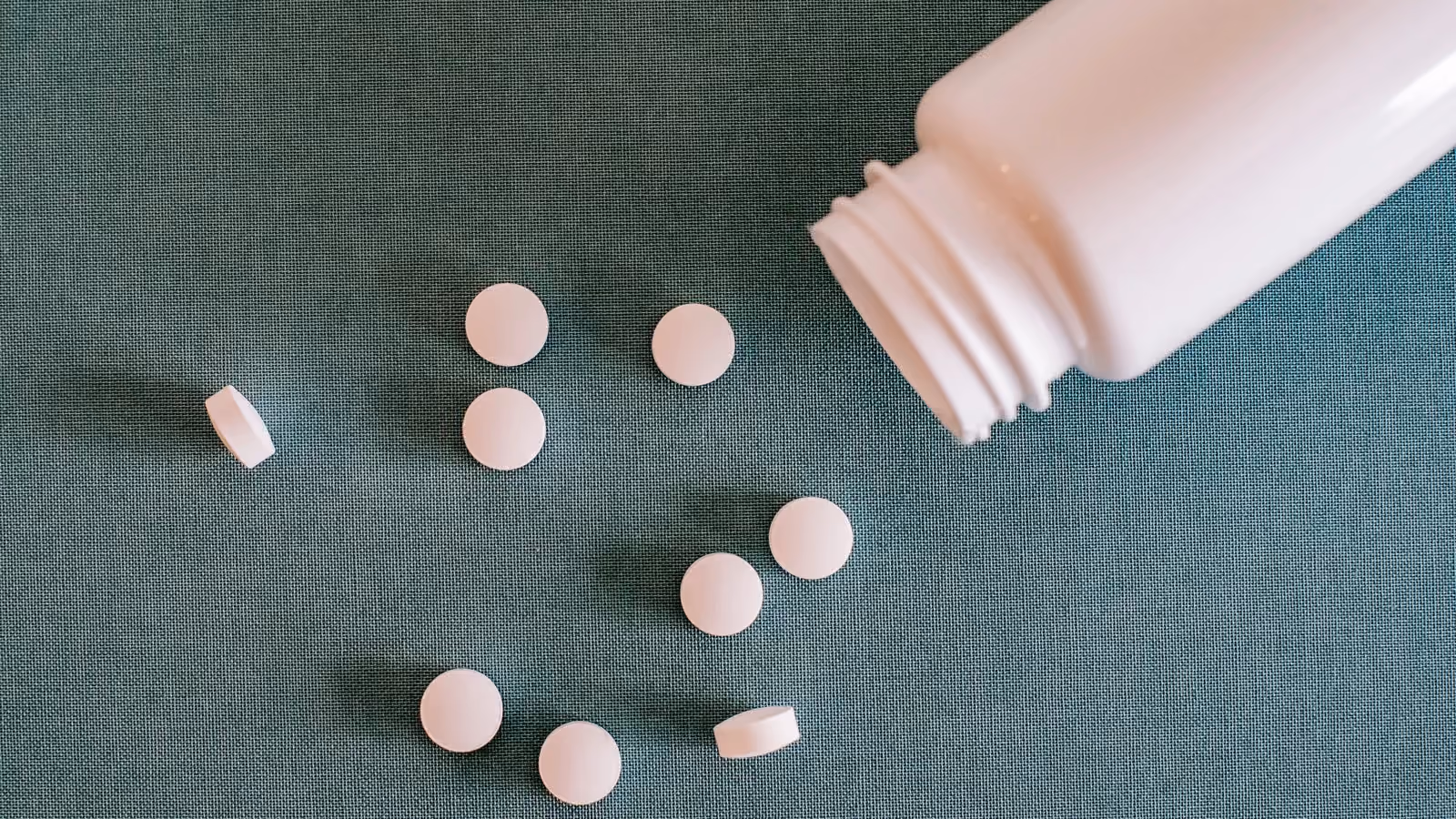 Mucchio di pillole bianche con contenitore — Alex Green – Pexels