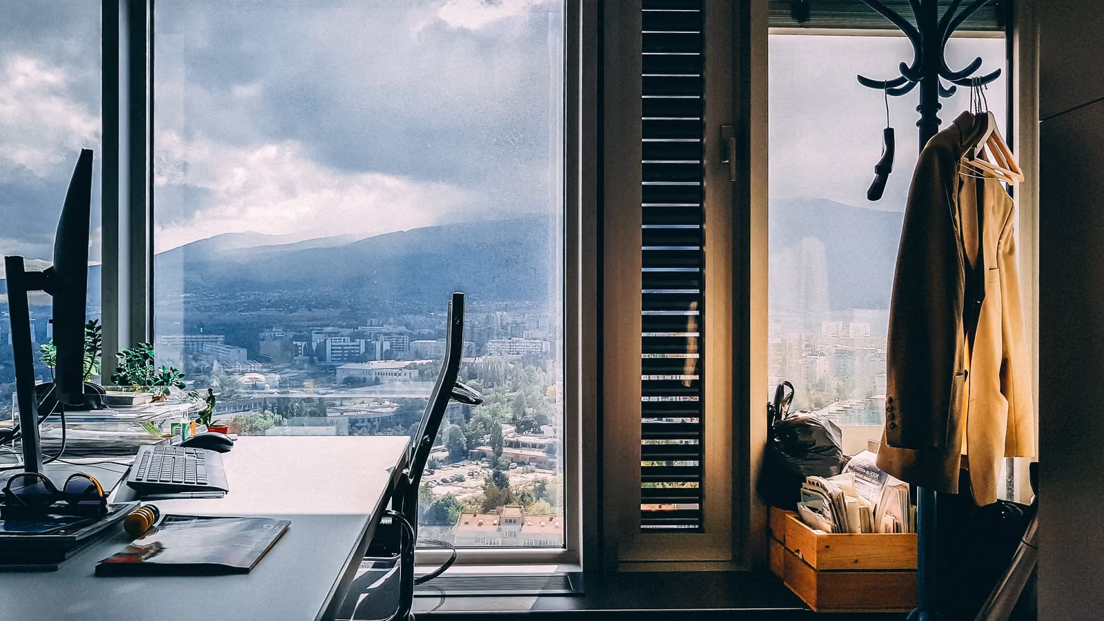 Un ambiente d'ufficio contemporaneo con una vista mozzafiato sulle montagne attraverso grandi finestre e arredi eleganti. — Hristo Sahatchiev – Pexels