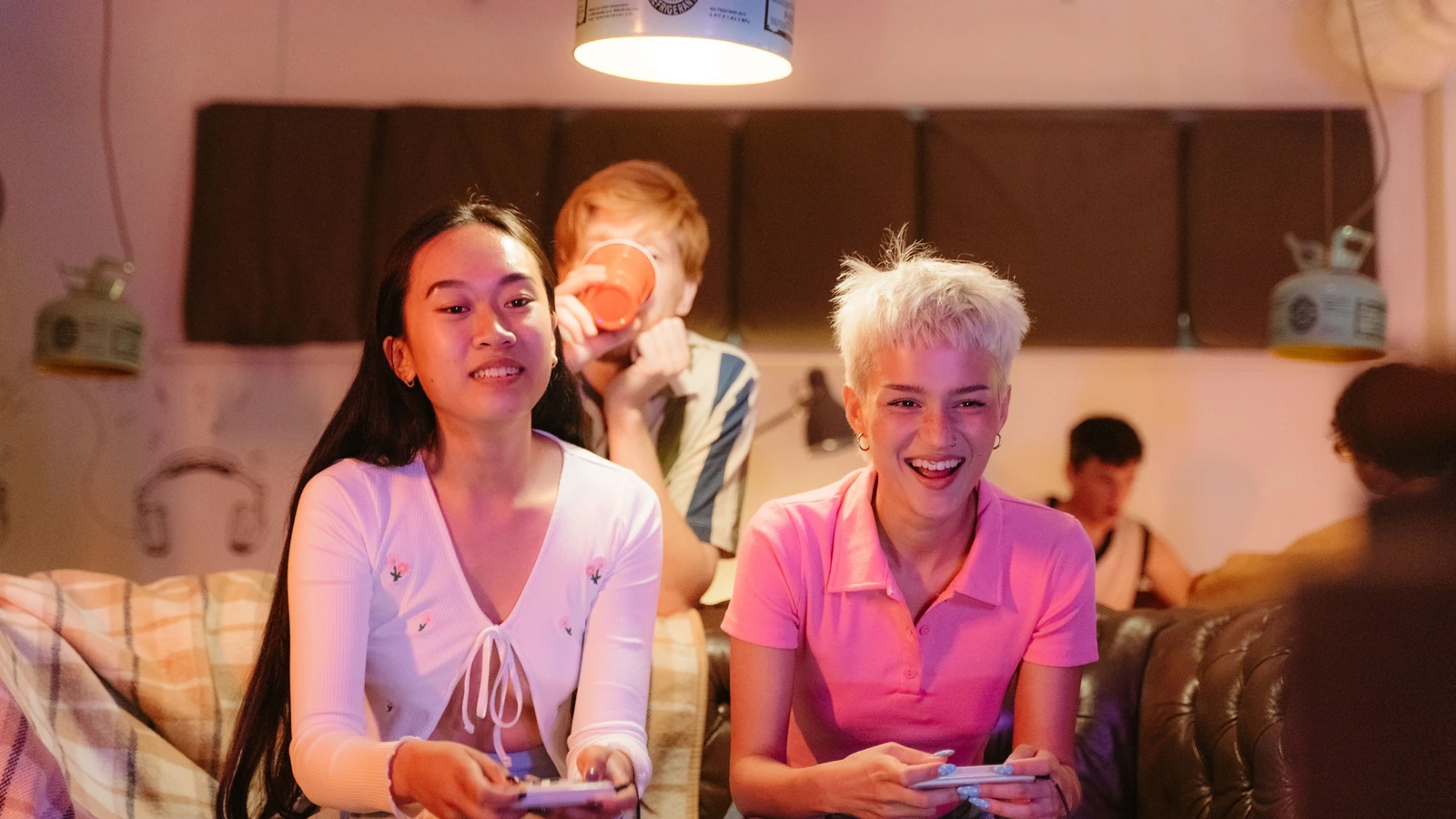 Un gruppo di adolescenti che gioca ai videogiochi e si diverte al chiuso, mostrando gioia e amicizia.