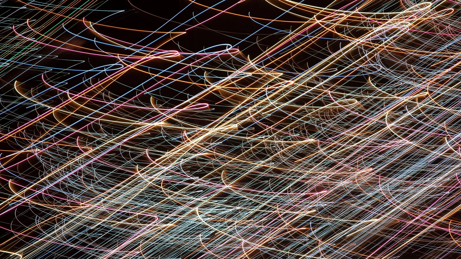 Immagine astratta dinamica che mette in mostra strisce di luce colorate su uno sfondo scuro, catturando il movimento.